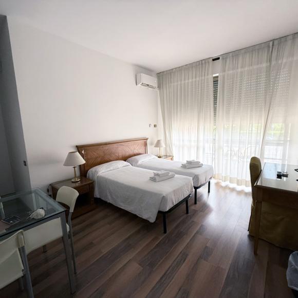 Bright room, two beds, modern decor, cozy and relaxing atmosphere.