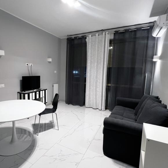 Modern, minimalist living room with neutral tones and a cozy atmosphere.
